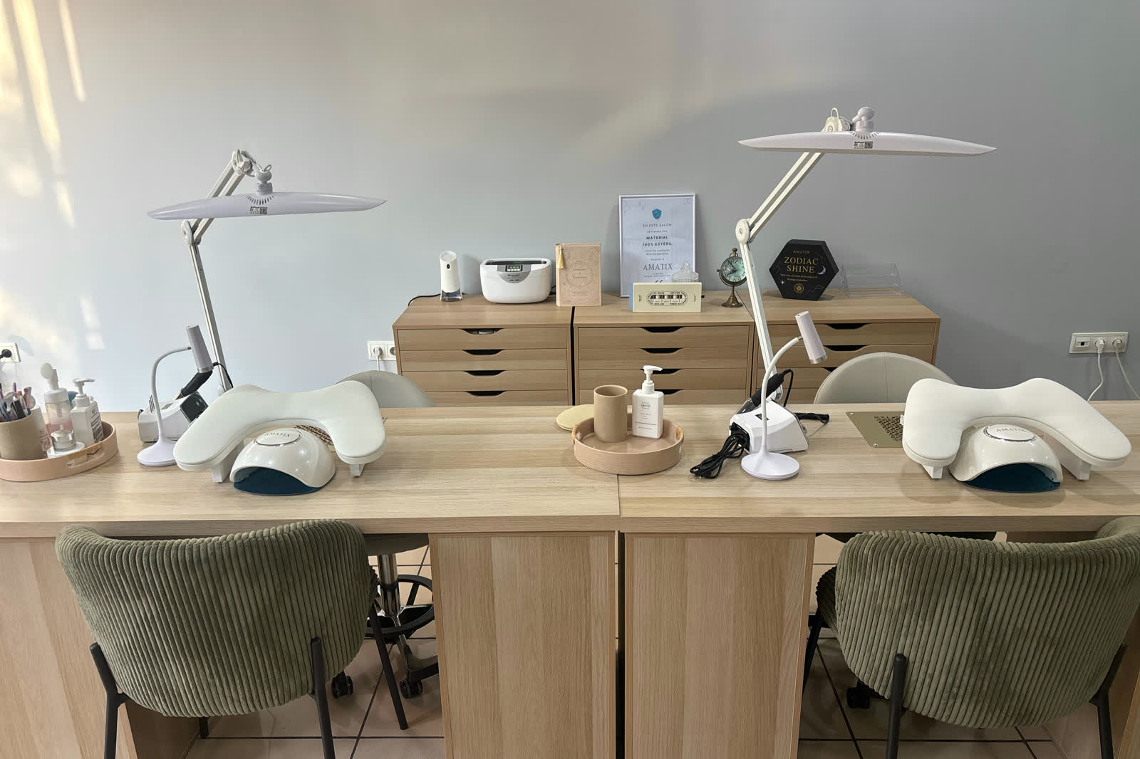 Los dos puestos de manicura del salón, en madera clara y con lámparas de trabajo