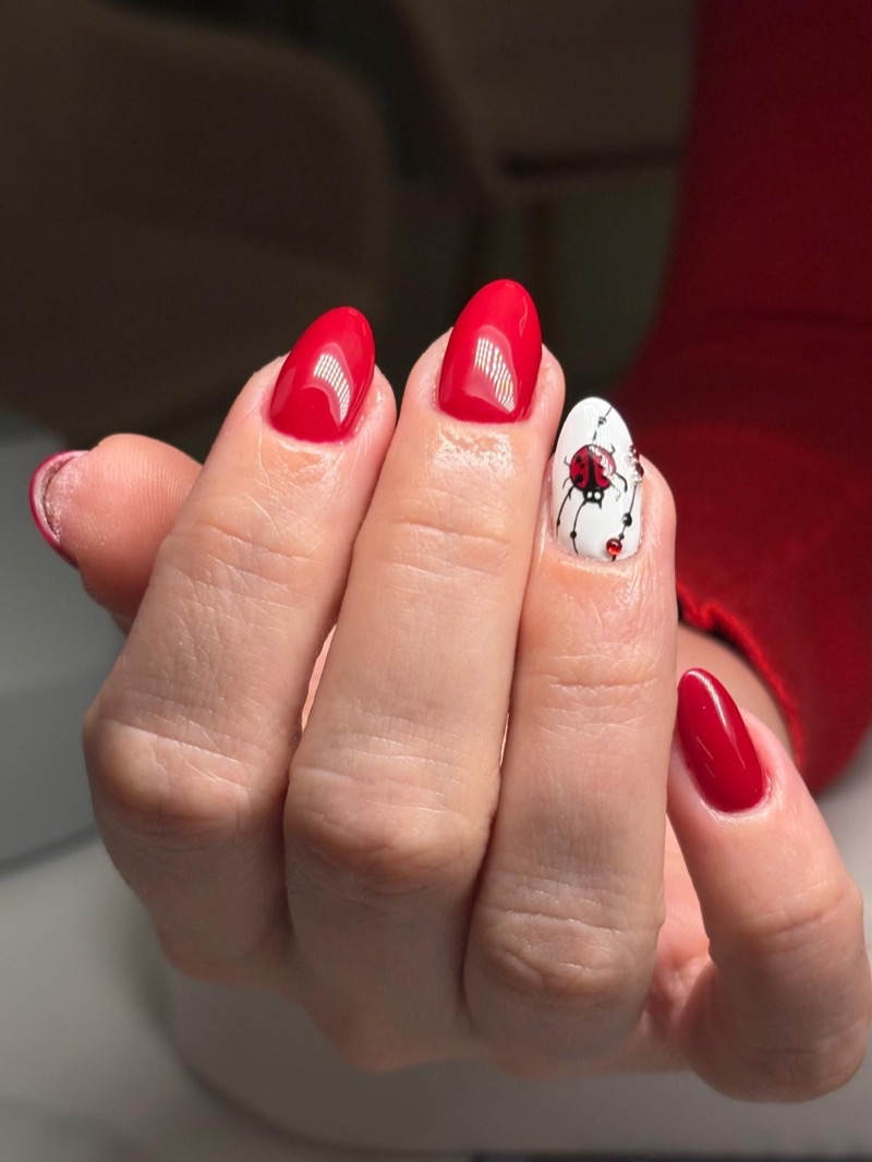 Uñas rojas con detalle de mariquita y pedrería